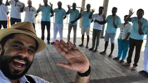 Khalid Khalid poses for a selfie with resort staff