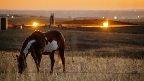 Getty Images Flames from a flaring pit near a well in the Bakken Oil Field