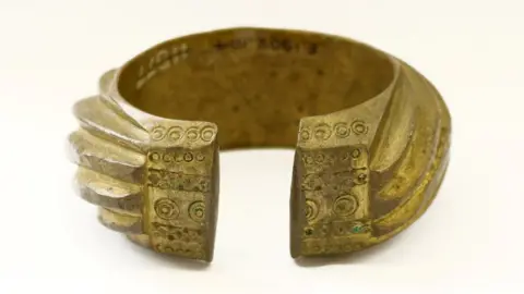 University of Cambridge A brass penannular bracelet decorated with heavy slanting bands