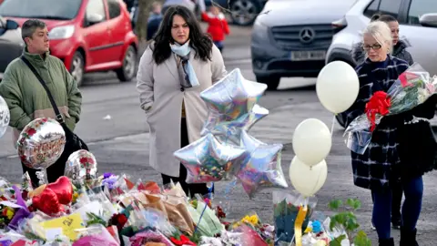 PA Media Women lay flowers