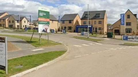 Google Entrance to new housing estate with marketing boards