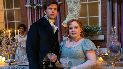 Netflix Luke Newton as Colin Bridgerton and Nicola Coughlan as Penelope Featherington in Bridgerton