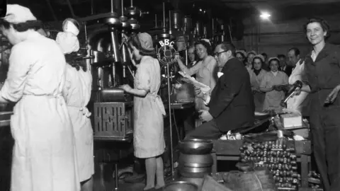 BBC Victor Smythe reads a script at a munitions factory