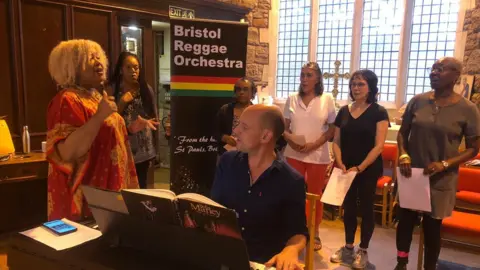 The choir singing along with pianist