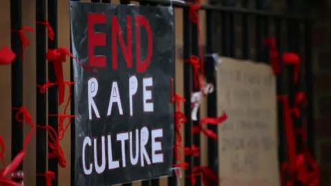 Getty Images A placard saying 'End Rape Culture' attached to the fence outside a London school