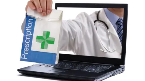 Getty Images Pharmacist handing bag of drugs through laptop screen