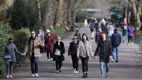 Reuters People walking through Battersea Park