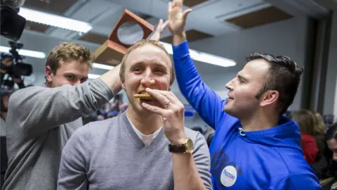 Al Drago / Getty Images A previous supporter of Democratic presidential candidate Martin O'Malley eats a cookie as he is persuaded to support Democratic presidential candidate Sen. Bernie Sanders during caucus night at the State Historical Society of Iowa, on Monday, Feb. 1, 2016 in Des Moines, Iowa.