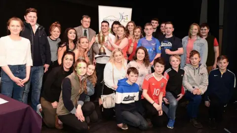 Andrew Bufton Erwood YFC Cast members being presented with the winning trophy at the Brecknockshire YFC panto finals