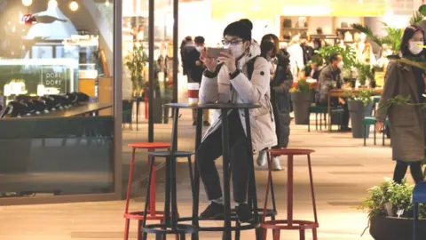 Reuters Man uses mobile phone in shopping mall in Seoul - 2 December