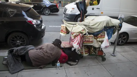 Getty Images Homeless man sleeps on the street in San Francisco (file photo)