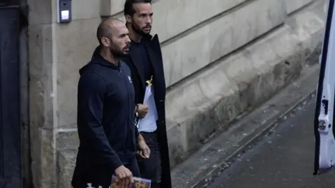 Reuters Andrew Tate and his brother Tristan are escorted by police officers outside the headquarters of the Bucharest Court of Appeal, in Bucharest, Romania, on 10 January 2023