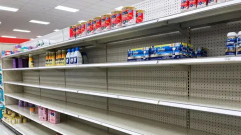 Getty Images A nearly empty baby formula display shelf is seen at a Target store in Orlando. Stores across the United States have struggled to stock enough baby formula, causing some chains to limit customer purchases.