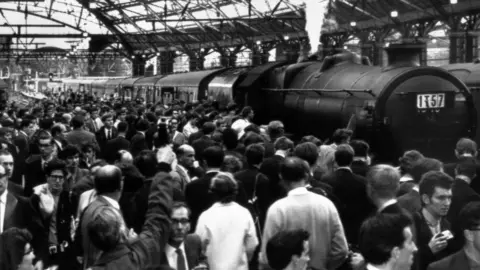 PA Thousands of people straining to get a look at Britain's last mainline steam passenger train