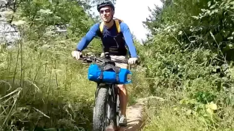 Jon Cuthill rides mountain bike down overgrown path