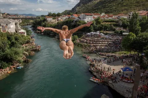 Damir Sagolj / Getty Images A competitor dives from Stari Most, also known as Old Bridge, on 26 July 2020, in Mostar, Bosnia and Herzegovina