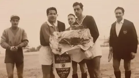 Maher Mezahi Referee standing with other players