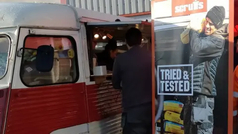 Tradesman standing outside food van