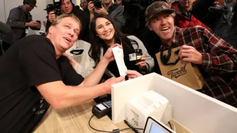 Reuters Customers Nikki Rose (centre) and Ian Power (right) with Canopy Growth CEO Bruce Linton (left) at Tweed in St John's Newfoundland, 17 October 2018