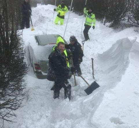 Officers have been lent poles to search for vehicles buried in the snow on the A386 in Devon.