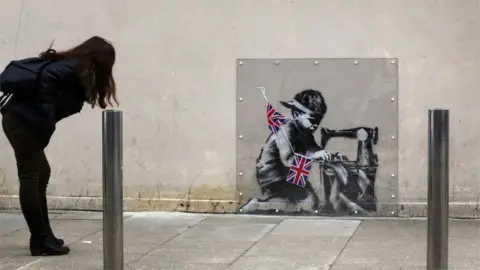 Getty Images Woman looking at Banksy mural