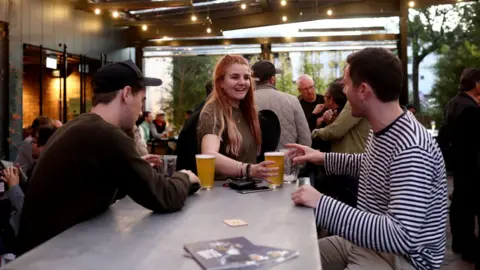 Getty Images Clients enjoy drinks and table service at a bar in Auckland