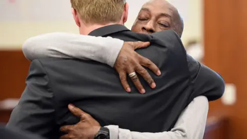 AFP DeWayne Johnson hugs one of his lawyers after hearing the verdict at the Superior Court Of California in San Francisco, on August 10, 2018