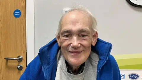 Ollie Conopo/BBC Man with white hair wearing a blue fleece