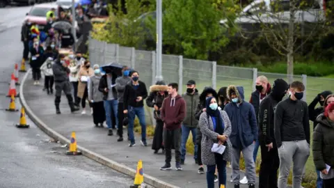 Getty Images People queuing for a jab in Bolton