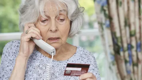 Pensioner with phone and credit card