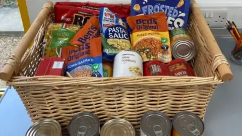 Milton Keynes Hospital Basket of tinned and packaged food on a table within the staff area of Milton Keynes Hospital