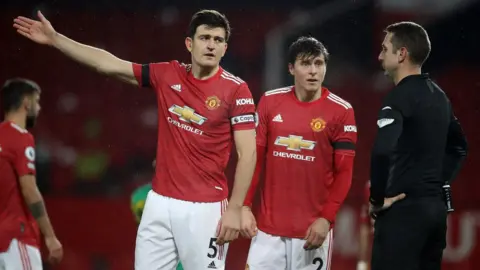 Harry Maguire protesting a decision with referee David Coote