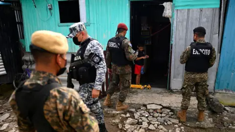 Getty Images Armed police search homes for suspected gang members