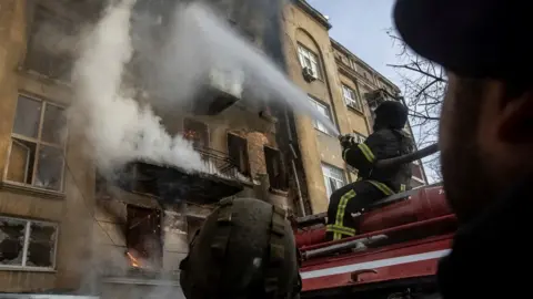 Reuters Firefighters put out a blaze at a residential building hit by a Russian military strike in Bakhmut