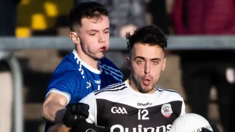 Kilcoo's Ryan Johnston is challenged by Naomh Conaill's Eoghan McGettigan
