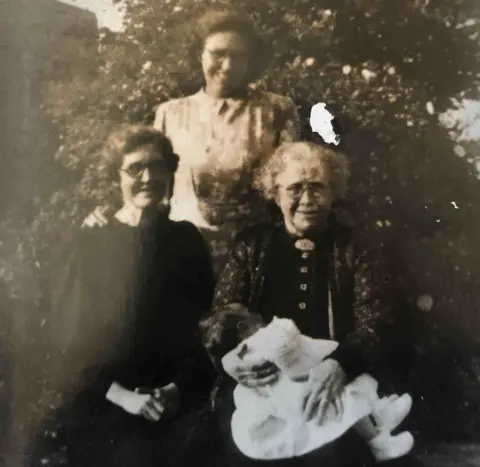 PA Media Handout photo from 1951 of Jean Thompson held by her great grandmother Mary Jane Blackmore (front right) on her 90th birthday, with her mother Mary Ann Blackmore (left) - who was gifted the chocolates in 1902 - and her grandmother Lena Milburn