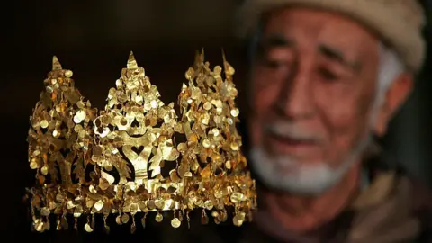 Getty Images A curator of the National Museum in Kabul with the golden crown found at Tela Tepe, on display in Amsterdam in 2007