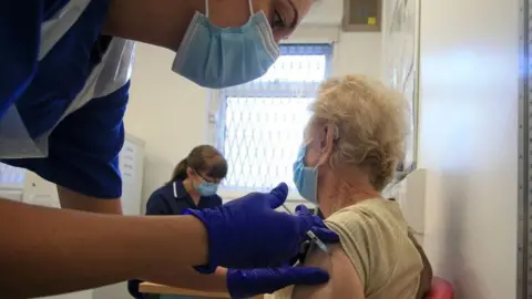 Getty Images An older woman getting vaccinated earlier in the pandemic