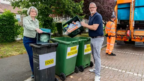 South Gloucestershire Council Two people load rubbish into bins