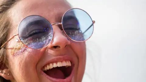 Getty Images A woman with glitter on her face