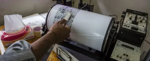 Getty Images A scientist records seismic activity around Mt Agung, Bali (24 Sept 2017)