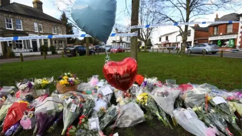 PA Media Floral tributes outside the pub