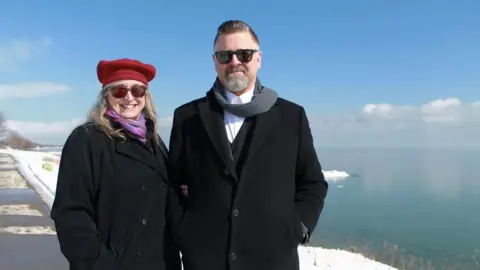 BBC Tina and Jason Prigge stand in front of Lake Michigan