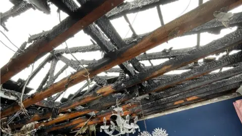 Essex Fire and Rescue Blackened timber beams of a rood destroyed by fire.