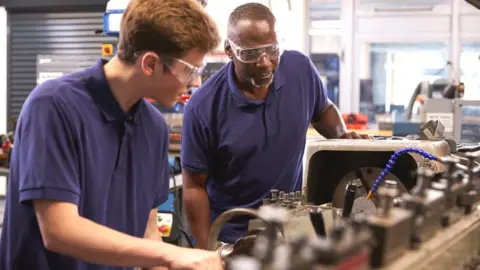 Getty Images Workers using a lathe