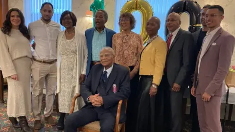 Shirley Henry/BBC Mr Ottey pictured with friends and members of his family