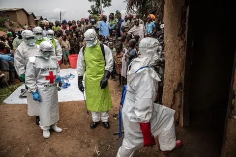 Finbarr O'Reilly for Fondation Carmignac Neighbours and Red Cross burial workers in protective clothing gather outside a home