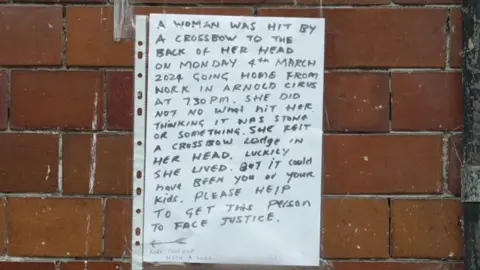 Handwritten appeal poster taped to a brick wall.