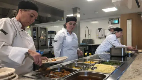 cooks putting food onto trays