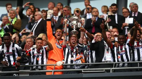 Charlie Crowhurst/Getty Images Grimsby's Craig Disley lifts the trophy as he celebrates the side's Vanarama Football Conference League Play Off Final win in 2016
